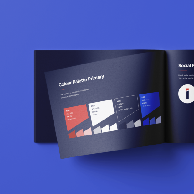 Mockup of an open brand guidelines booklet showing a 'Colour Palette Primary' page with red, white, navy, and blue swatches and their RGB/CMYK values