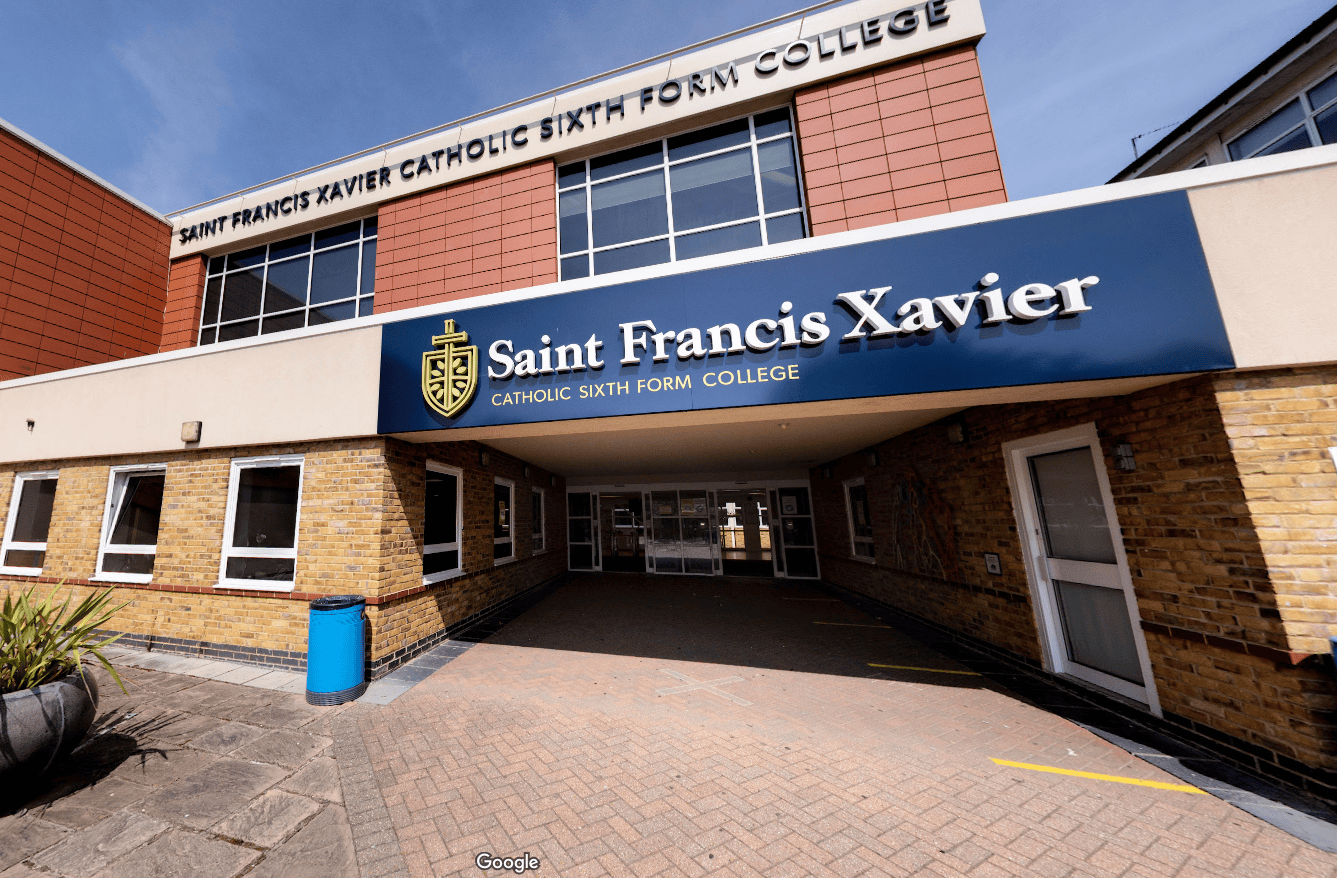 Front entrance of Saint Francis Xavier Catholic Sixth Form College, with the college's name and crest displayed above the covered walkway.